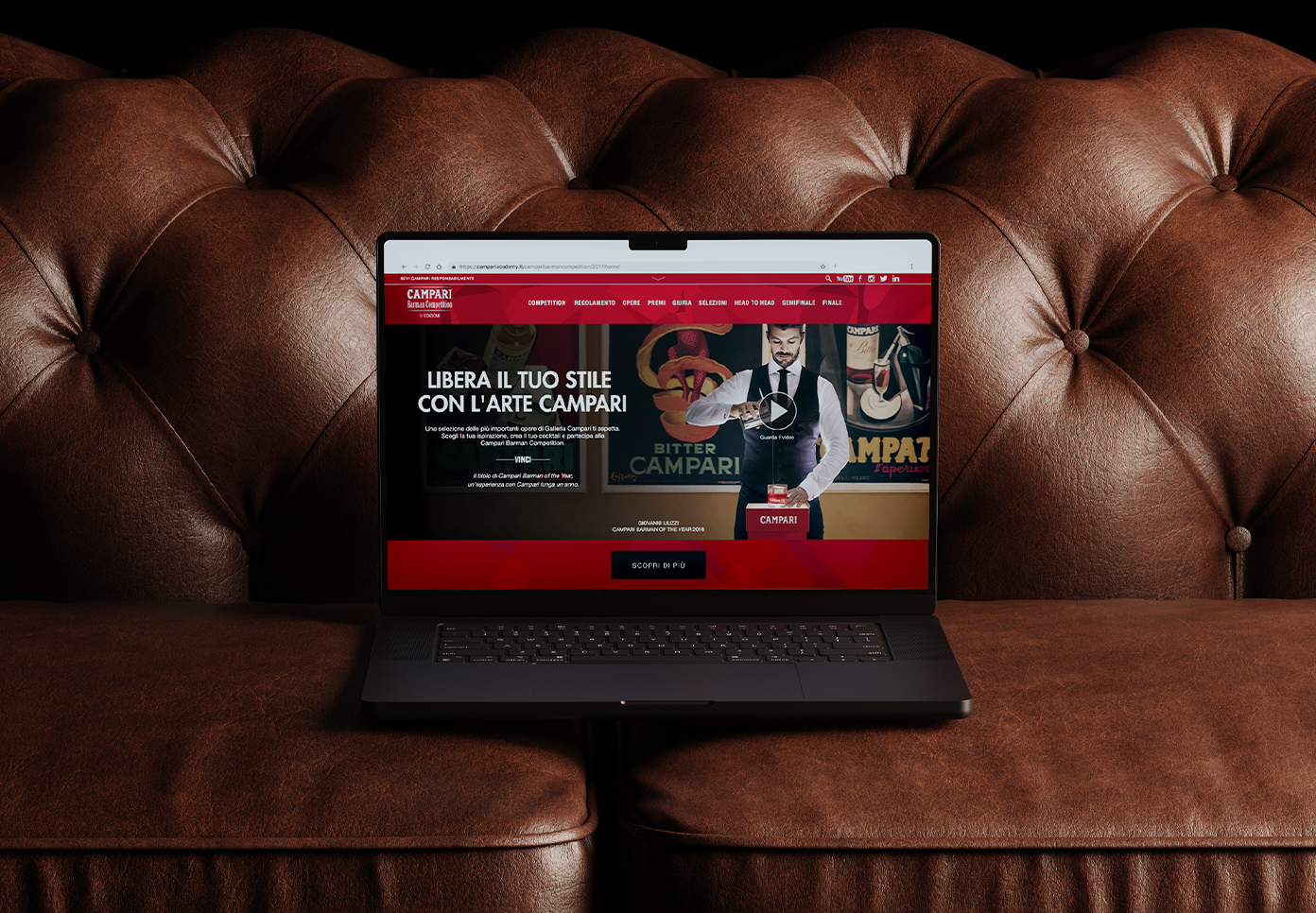 Campari Barman Competition website interface displayed on a laptop placed on a leather sofa.