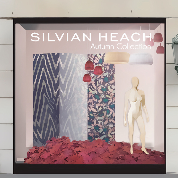 Autumn showcase window with layered panels, mannequins and warm-toned decorative elements.